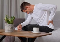 Man suffering from low back pain home pain relief concept